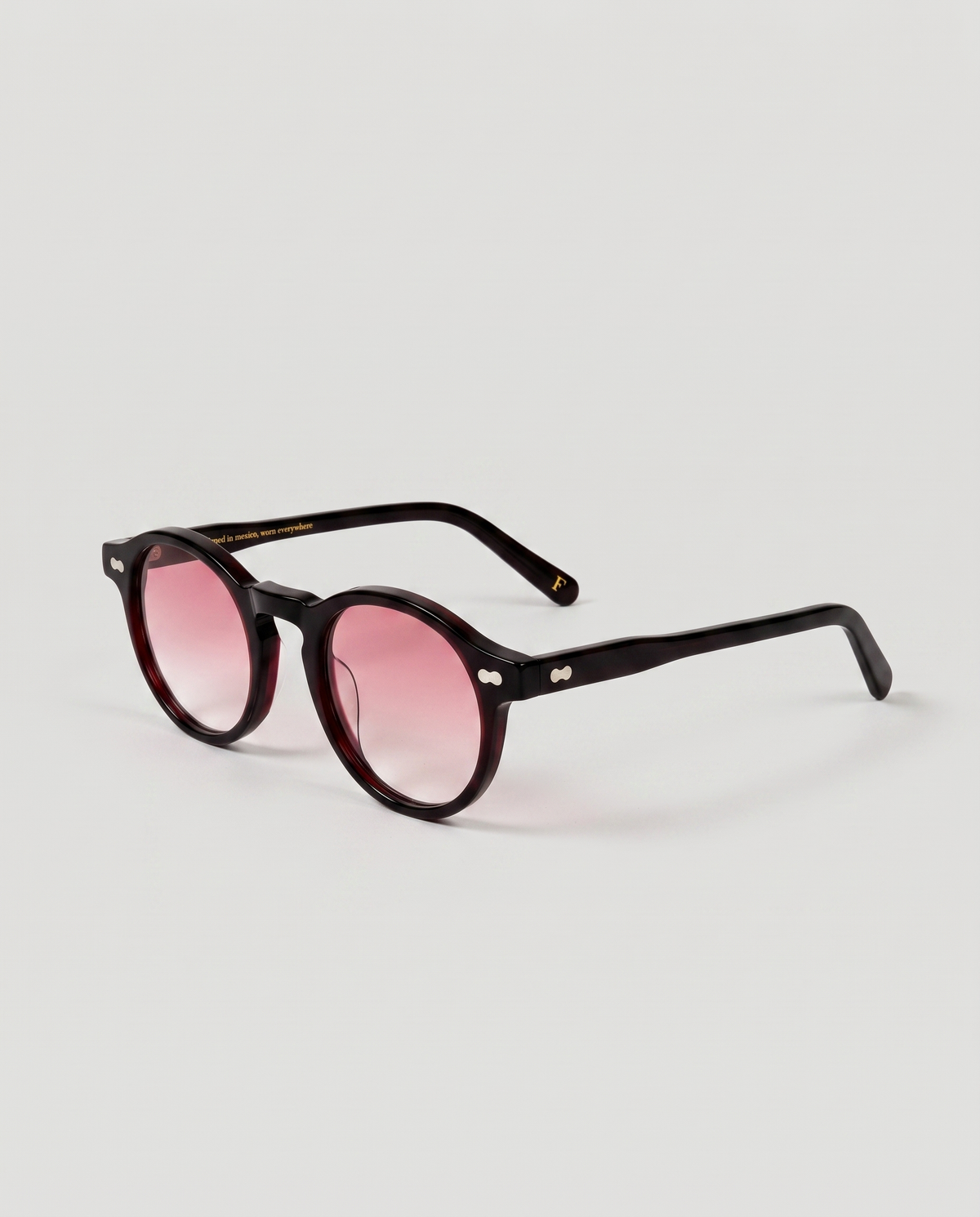 lentes de sol freddi campari, acetato vino oscuro translúcido con lente rosa degradado, vista tres cuartos