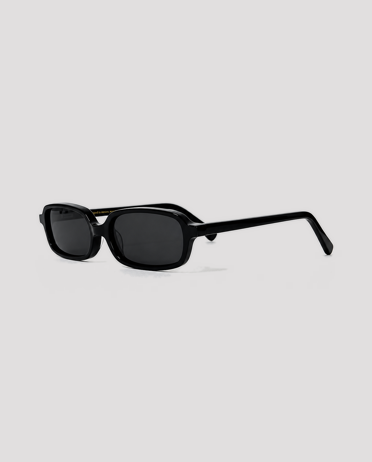 lentes de sol freddi viena, acetato negro rectangular con lente gris, vista tres cuartos