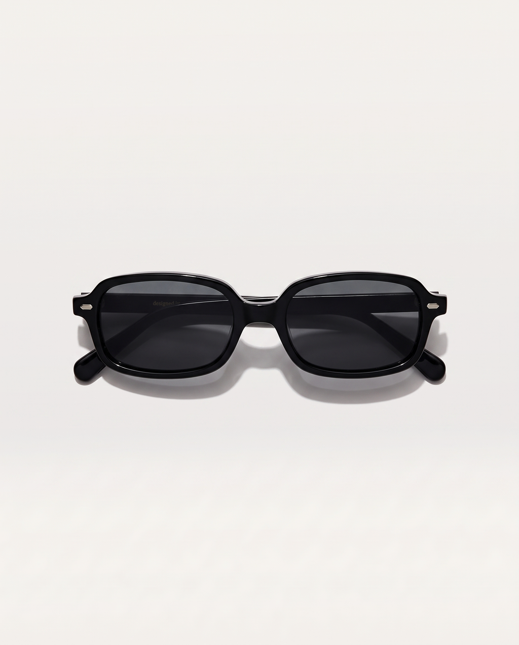lentes de sol freddi viena, acetato negro rectangular, vista superior plegados